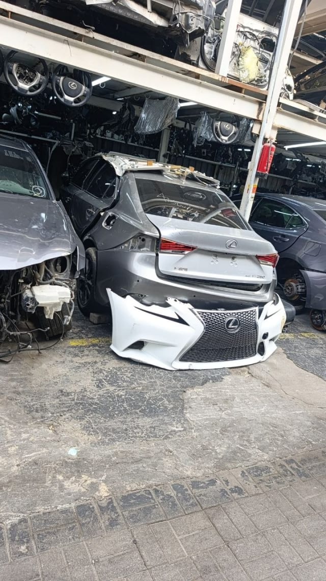 Silver Lexus IS sedan rear halfcut with tail lights and white F-Sport front bumper, Sharjah market