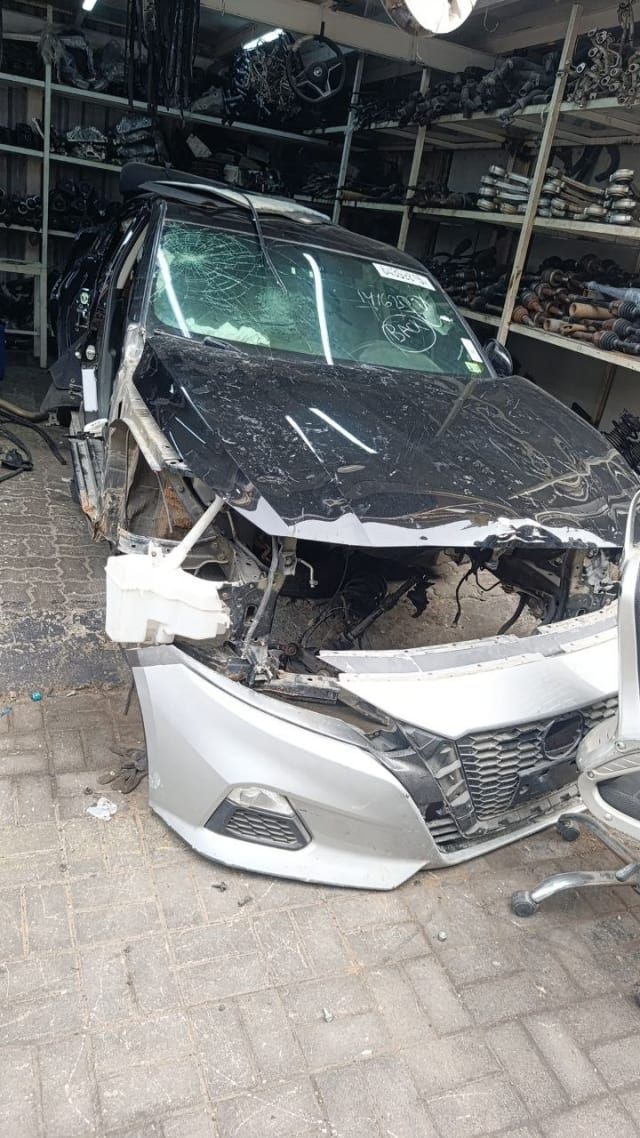 Black Nissan Altima sedan halfcut with silver front bumper, grille, hood and exposed engine bay, Sharjah market