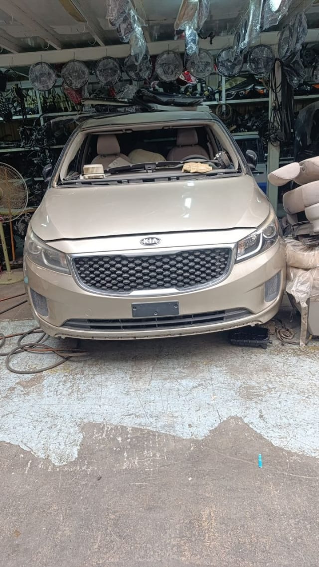 Beige Kia Sedona minivan front halfcut — bumper, grille, headlights and hood, Sharjah market