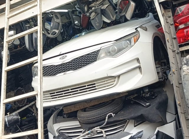 White Kia Optima sedan front halfcut — bumper, grille and headlights, Sharjah market