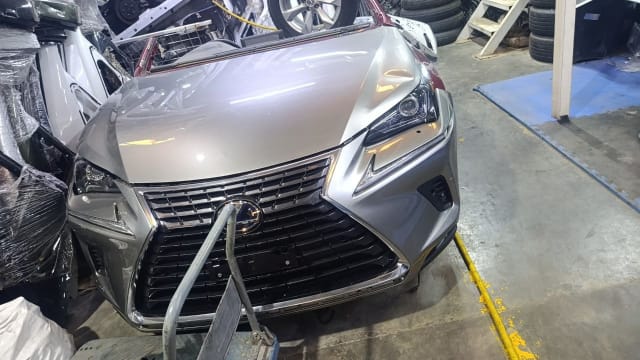 Silver Lexus NX SUV front halfcut — spindle grille, bumper, headlights and hood, Sharjah market