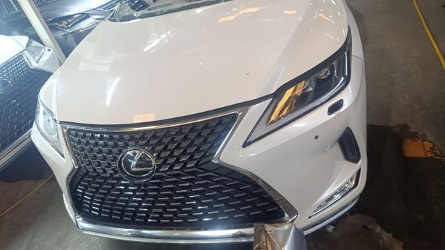 White Lexus RX SUV front halfcut — spindle grille, headlight, hood and bumper, Sharjah market
