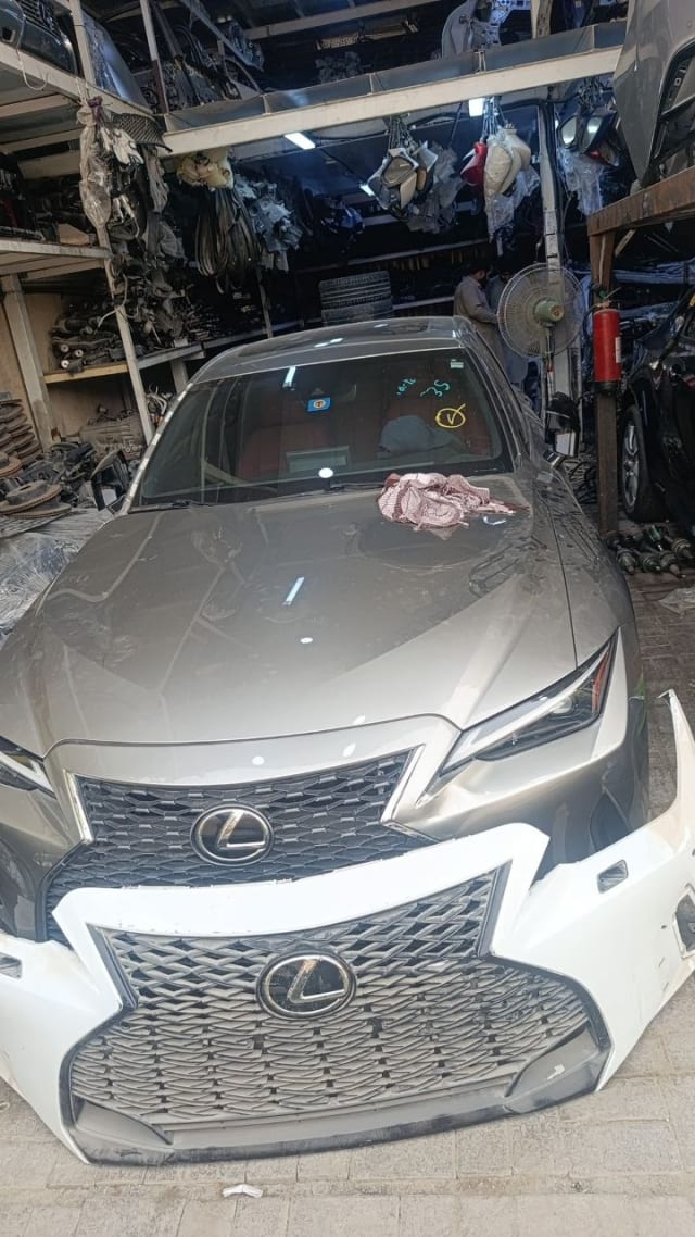 Grey Lexus IS sedan halfcut — hood, headlights and spindle grille with white front bumper, Sharjah market