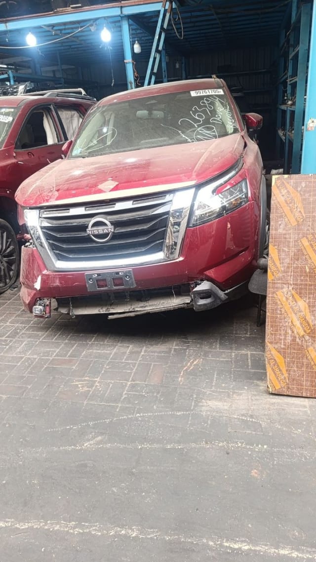 Dark red Nissan Pathfinder SUV front end — grille, headlights and hood, bumper removed, Sharjah market