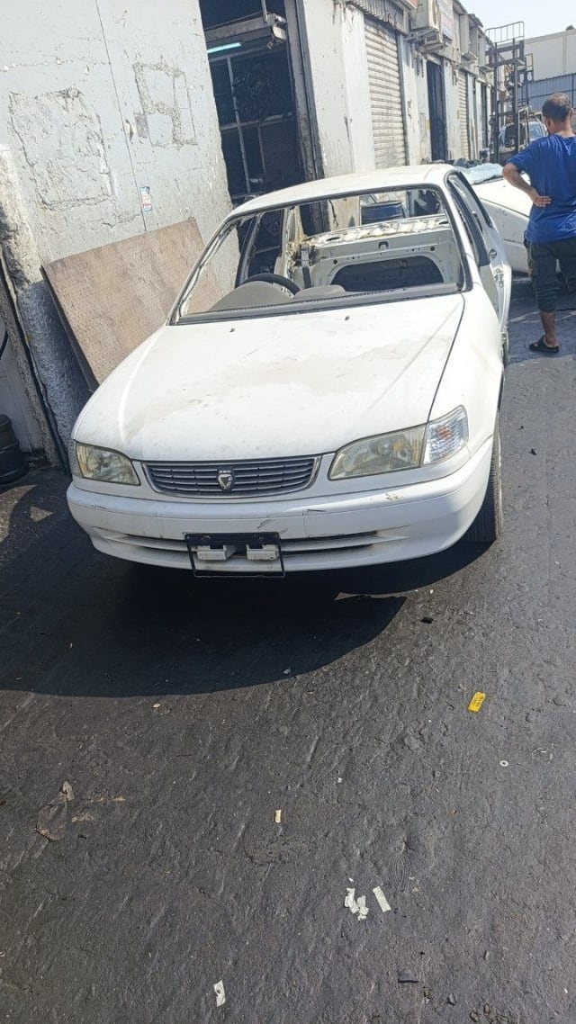 White Toyota Corolla sedan front — bumper, grille, headlights and hood, parts car, Sharjah market