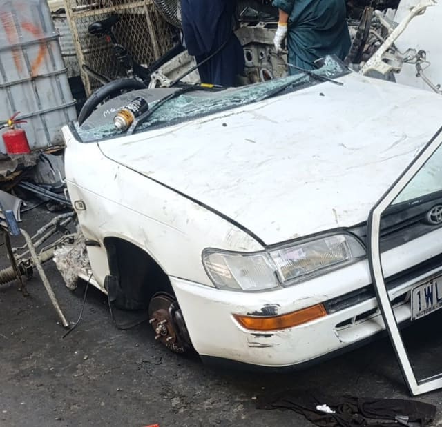 White Toyota Corolla sedan front halfcut — hood, headlight, bumper and fender, Sharjah market