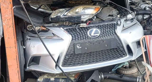 Silver Lexus IS sedan front halfcut — spindle grille, bumper and headlights, Sharjah market