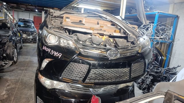 Black Toyota Camry sedan front halfcut — bumper, mesh grille and headlights, Sharjah market