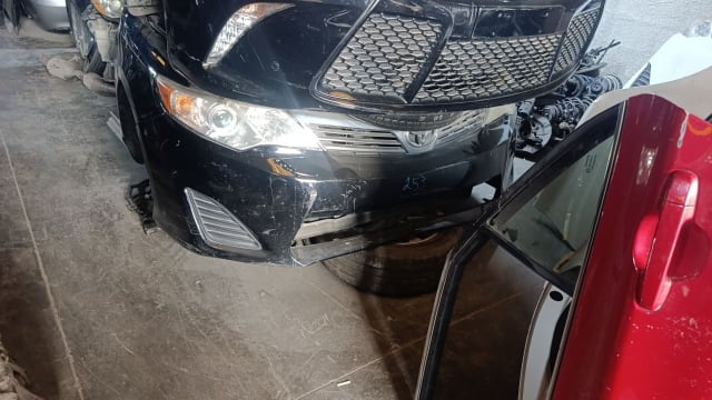 Black Toyota Camry sedan front halfcut — bumper, grille and headlights, Sharjah market