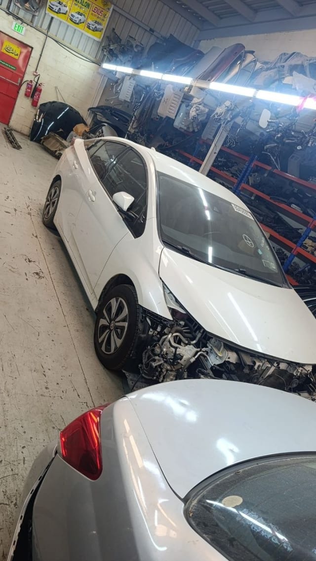 White Toyota Prius hatchback halfcut — front fender, door, wheel and exposed engine bay, Sharjah market