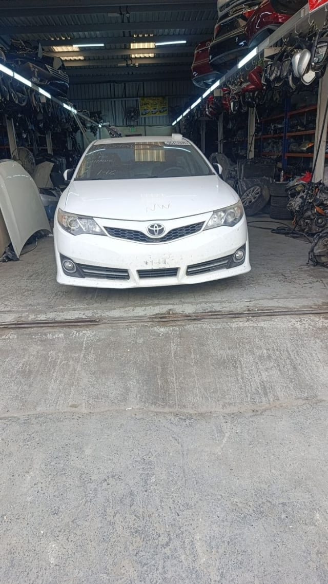 White Toyota Camry sedan front cut — bumper, grille, headlights and hood, Sharjah market