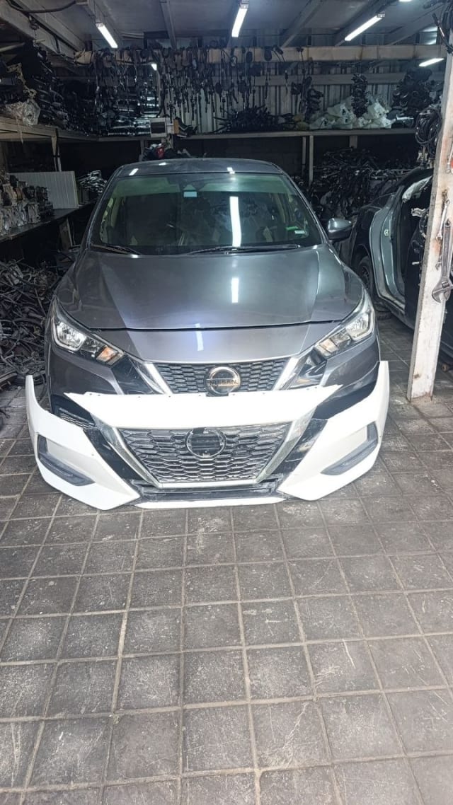 Grey Nissan Sunny sedan front halfcut — hood, headlights, grille and white front bumper, Sharjah market