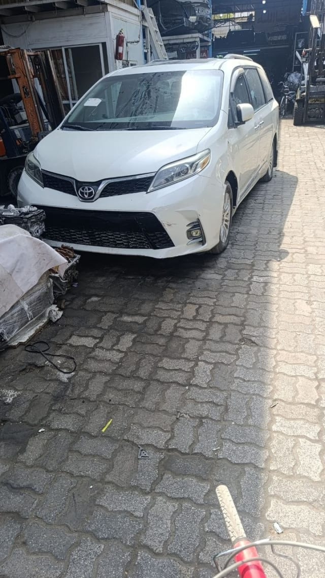 White Toyota Sienna minivan front cut — bumper, grille, headlights and hood, Sharjah market