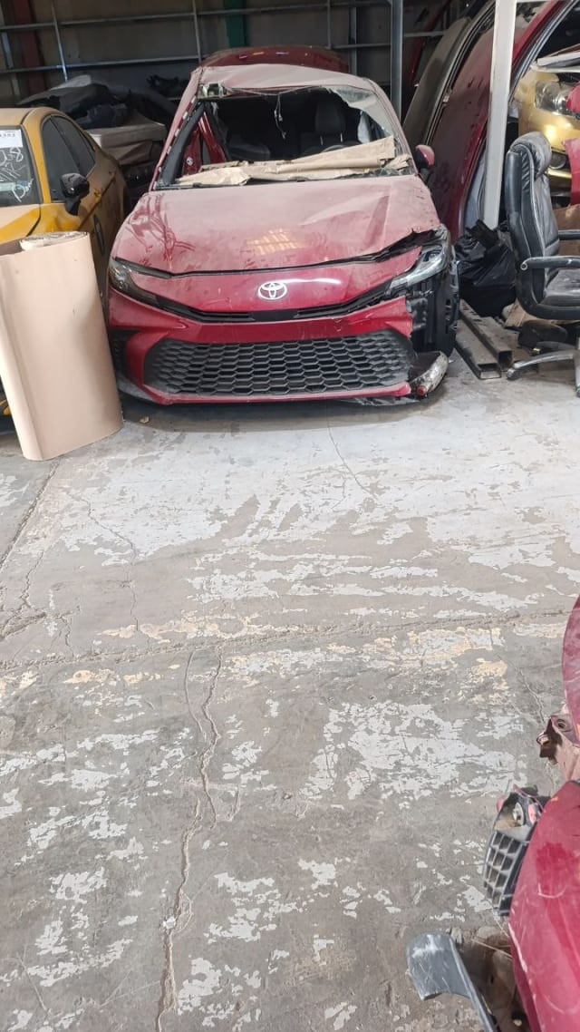 Dark red Toyota Camry sedan front halfcut — bumper, grille, hood and headlights, Sharjah market