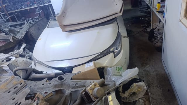 White Toyota Corolla sedan front halfcut — hood, headlight, grille and emblem, Sharjah market