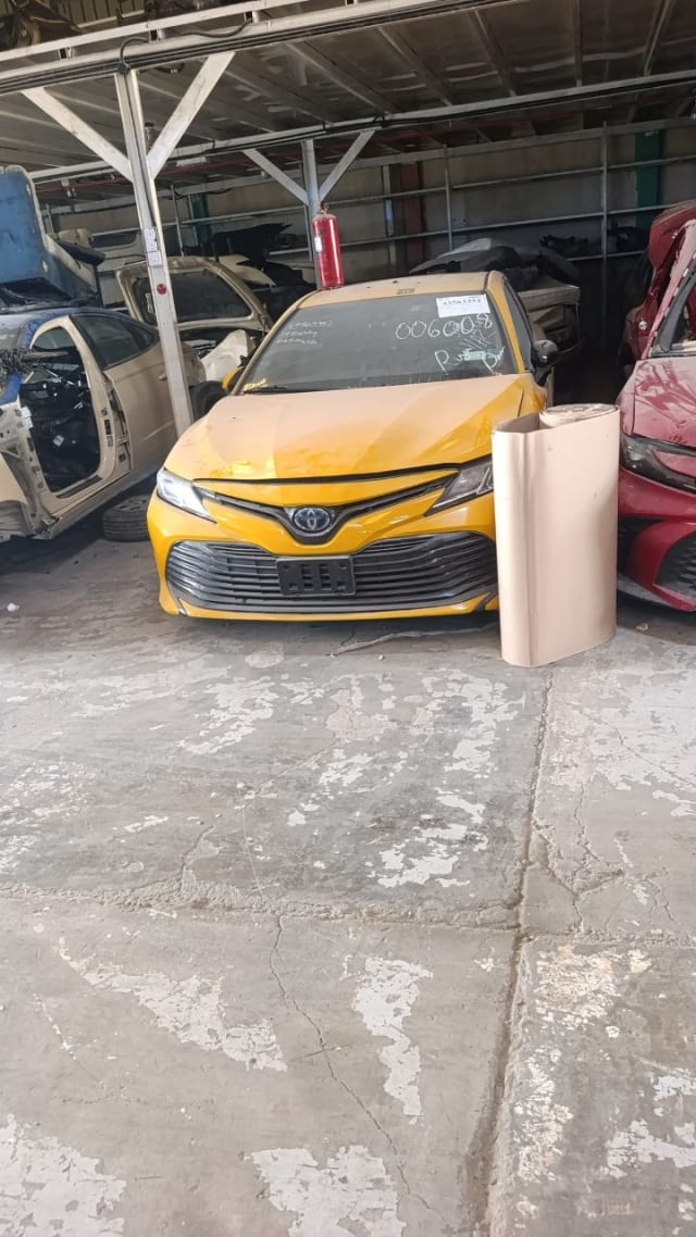 Yellow Toyota Camry sedan front end — hood, bumper, grille and headlights, Sharjah market