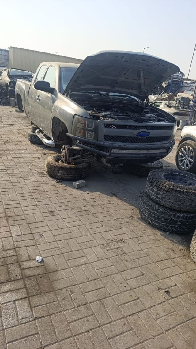 Grey Chevrolet Silverado 1500 pickup halfcut — grille, headlights, bumper and open hood, Sharjah market
