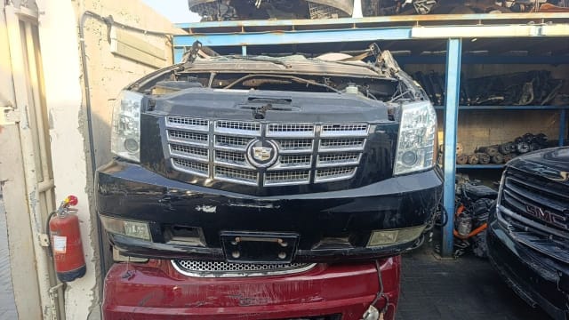 Black Cadillac Escalade SUV front cut — chrome grille, headlights and bumper, Sharjah market