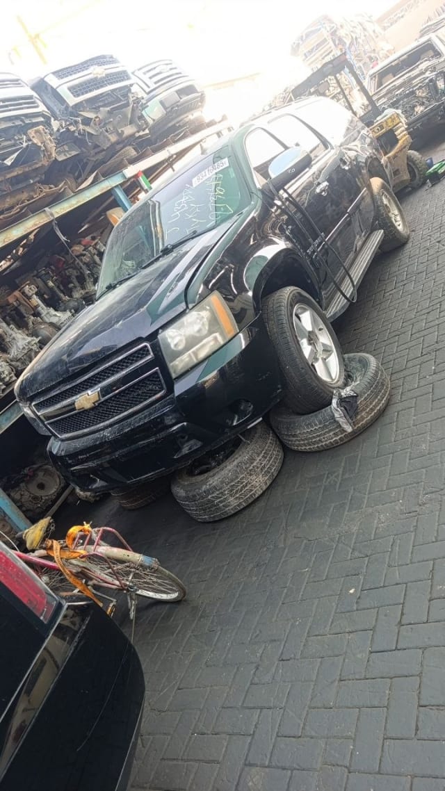 Black Chevrolet Tahoe SUV for parts — grille, headlights, bumper and alloy wheels, Sharjah market