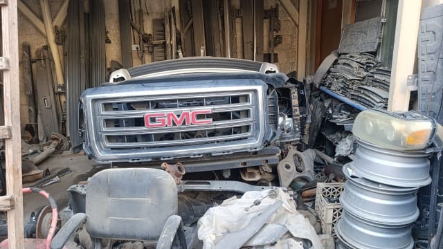 Dark grey GMC Sierra halfcut front cut — chrome grille, GMC emblem and front bumper, Sharjah market