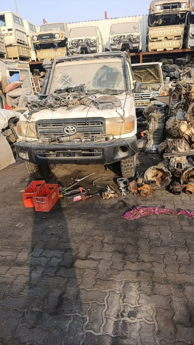 White Toyota Land Cruiser 70 Series halfcut — grille, bumper, headlights and stripped engine bay, Sharjah market