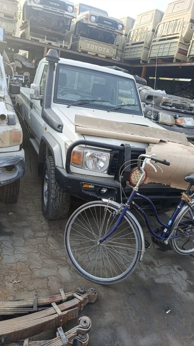 White Toyota Land Cruiser 79 single-cab pickup front — headlights, grille, bumper and bull bar, Sharjah market