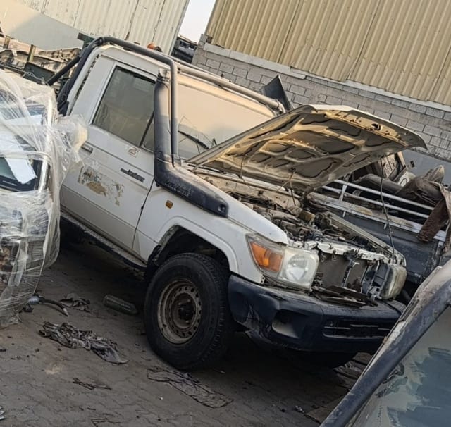 White Toyota Land Cruiser 70 single-cab halfcut — front cut, headlights, bumper, open hood, Sharjah market
