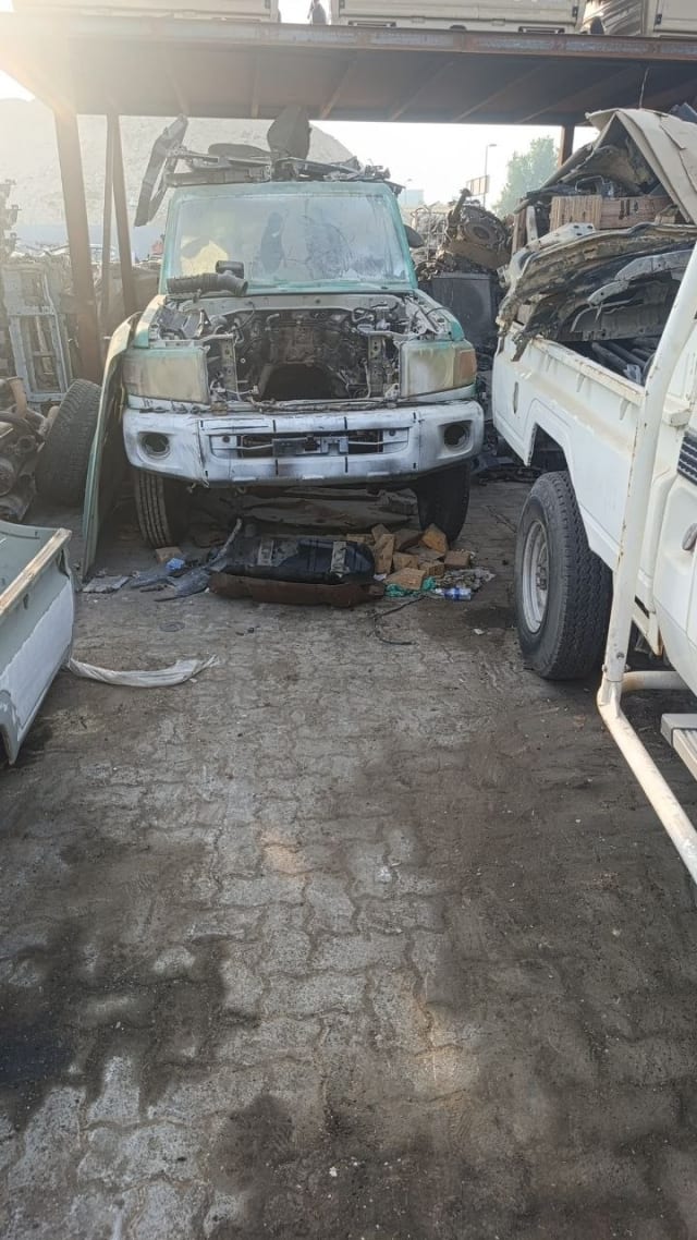 White and green Nissan Patrol SUV halfcut — front bumper, grille and stripped engine bay, Sharjah market