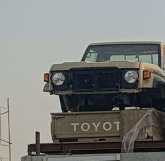 Beige Toyota Land Cruiser 70 Series pickup halfcut — headlights, cabin and radiator support, Sharjah market