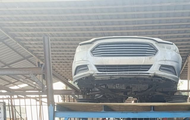 White Ford Fusion front halfcut — bumper, grille and headlights on rack, Sharjah market