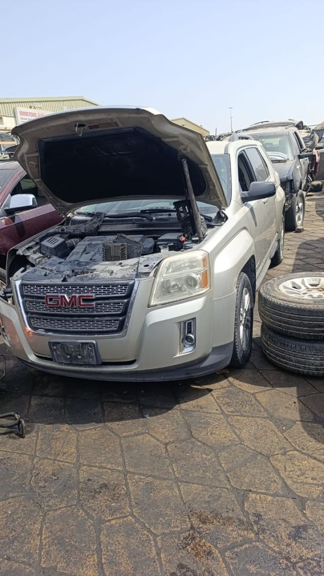 Silver GMC Terrain SUV for parts — grille, headlights, front bumper and open engine bay, Sharjah market