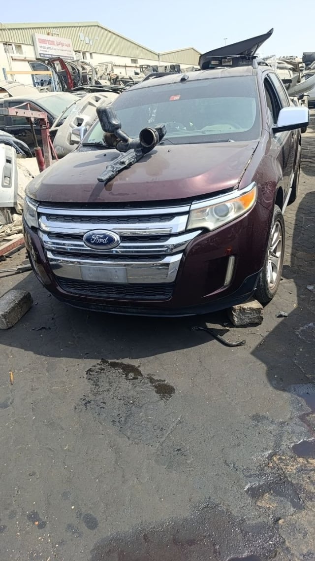 Dark maroon Ford Edge SUV front cut — bumper, chrome grille, headlights and hood, Sharjah market