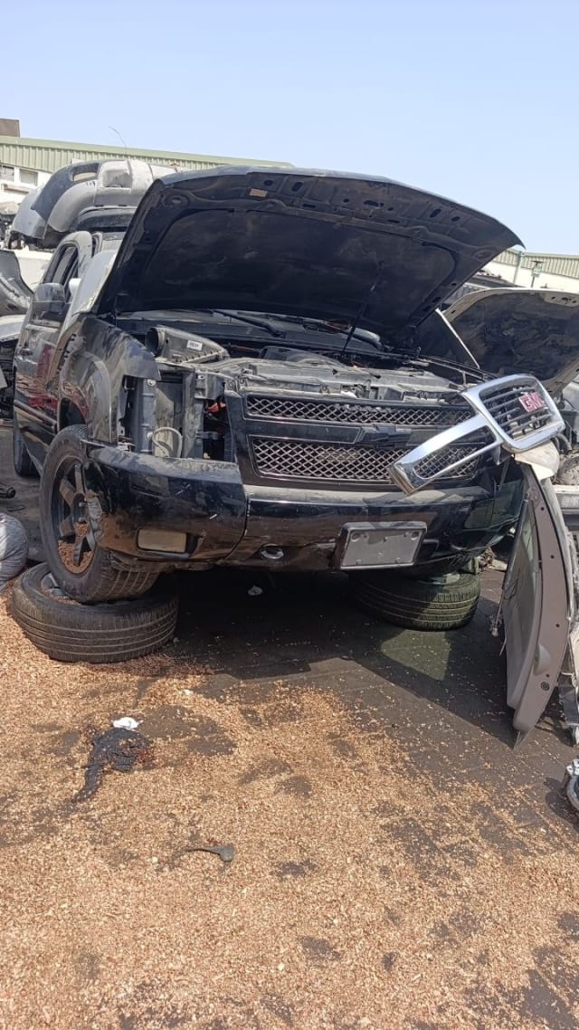 Black Chevrolet Tahoe SUV halfcut — front bumper, grille and open hood engine bay, Sharjah market