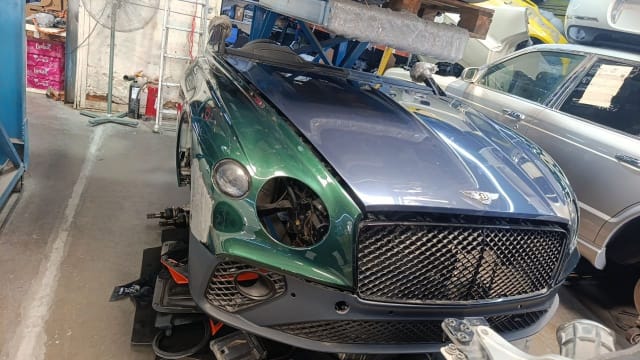 Green Bentley Continental GT coupe front halfcut — bumper, mesh grille, headlight and hood, Sharjah market