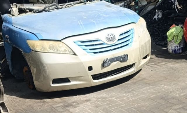 Blue and beige Toyota Camry sedan front halfcut — bumper, grille, headlights and hood, Sharjah market