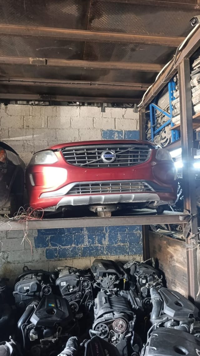 Red Volvo XC60 SUV front halfcut — bumper, grille and headlights on rack, Sharjah market