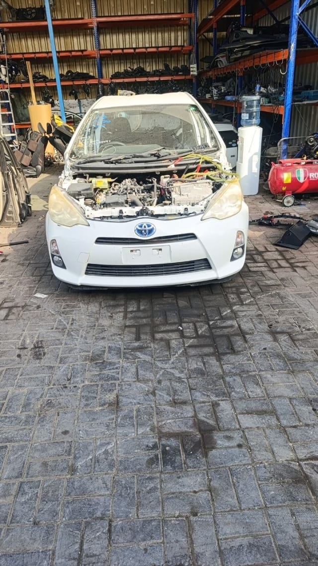 White Toyota Prius C / Aqua front halfcut — bumper, grille, headlights and engine bay, Sharjah market