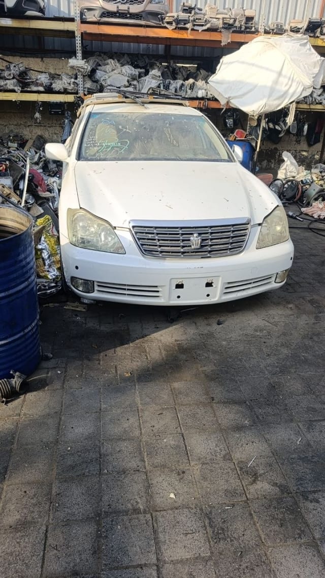 White Toyota Crown sedan front cut — bumper, chrome grille and headlights, Sharjah market