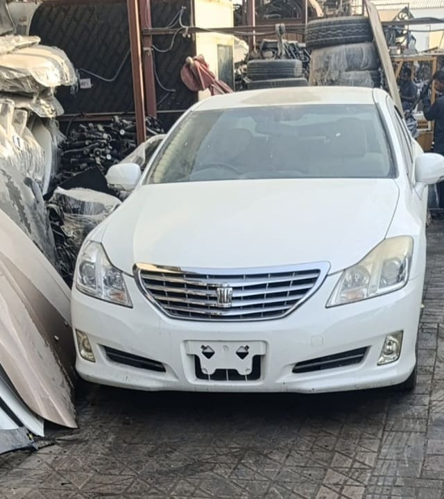 White Toyota Crown sedan front — bumper, chrome grille, headlights and hood, Sharjah market