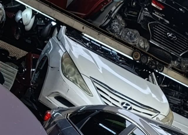 White Hyundai Sonata sedan front cut — bumper, grille, hood and headlights, Sharjah market