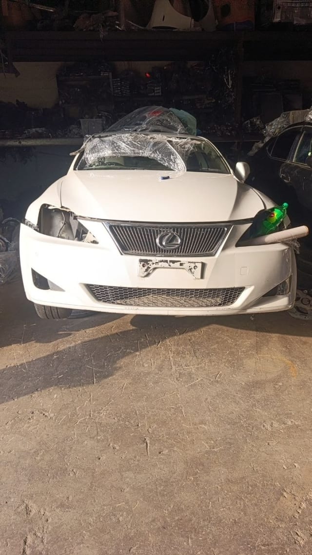 White Lexus IS sedan front cut — chrome grille, front bumper and hood, missing headlight, Sharjah market