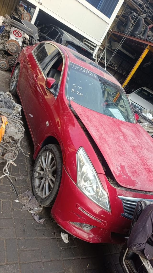 Red Infiniti G37 sedan front three-quarter — bumper, headlights, hood, grille and alloy wheel, Sharjah market