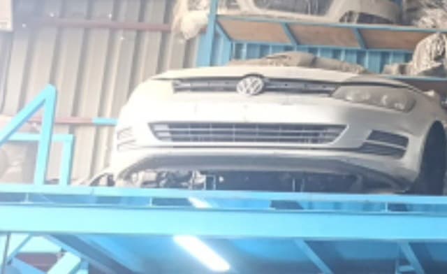 Silver Volkswagen Golf hatchback front halfcut — bumper, grille and headlights on a rack, Sharjah market