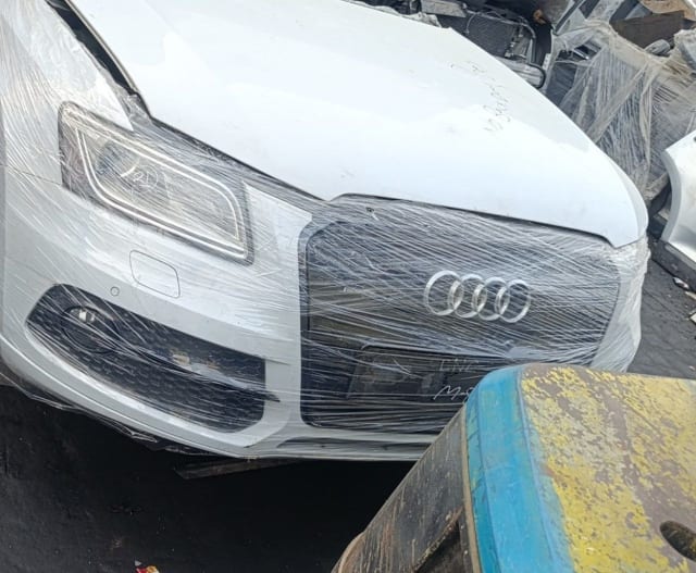White Audi A6 front cut wrapped in film — bumper, single-frame grille and headlight, Sharjah market