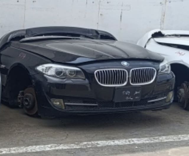 Black BMW 5-Series sedan front halfcut — hood, kidney grille, headlights and bumper, Sharjah market
