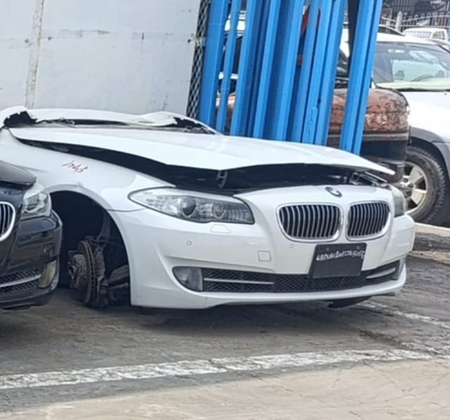 White BMW 5-Series sedan front halfcut — bumper, kidney grille and headlights, Sharjah market