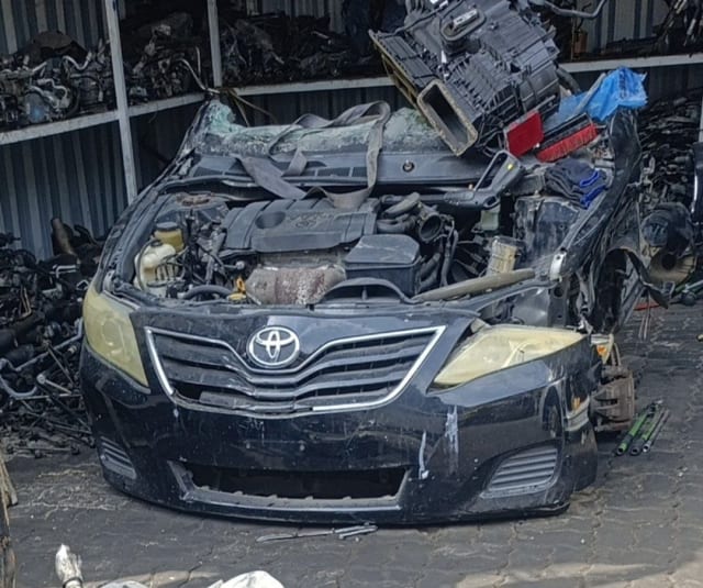 Black Toyota Camry sedan front halfcut — bumper, grille, headlights and engine bay, Sharjah market