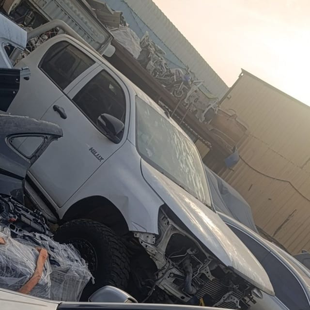 White Toyota Hilux pickup halfcut — cabin, front door, fender and exposed engine bay, Sharjah market