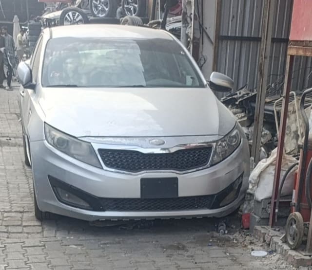 Silver Kia Optima sedan front — bumper, grille, headlights and hood, car for parts, Sharjah market