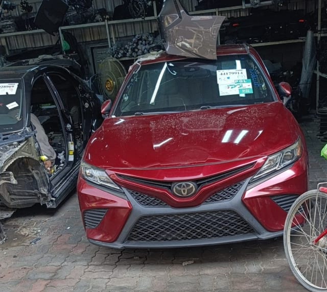 Red Toyota Camry sedan front cut — front bumper, grille, headlights and hood, Sharjah market